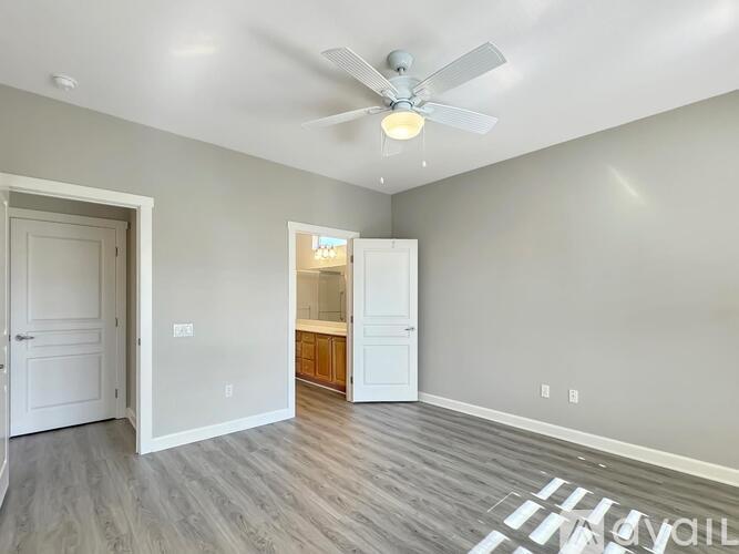 A room with a ceiling fan and a doorway leading to another room.