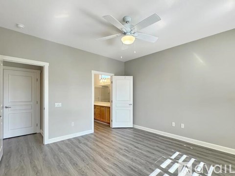 A room with a ceiling fan and a doorway leading to another room.