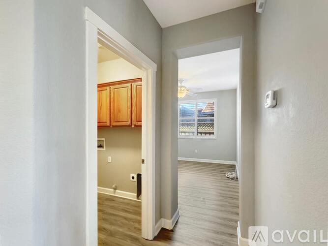 A hallway with a doorway leading to a kitchen area.
