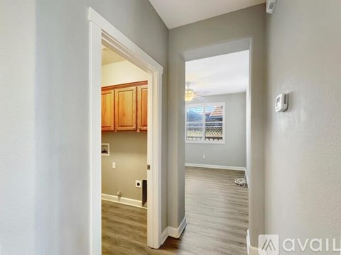 A hallway with a doorway leading to a kitchen area.