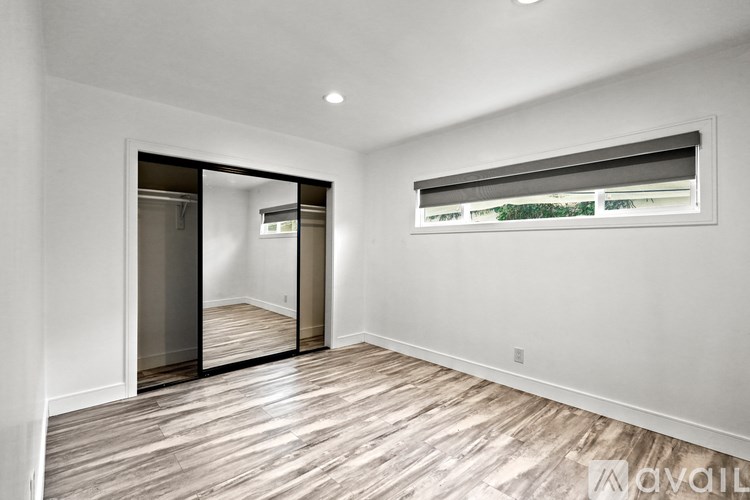 A room with a sliding door and a window with blinds.
