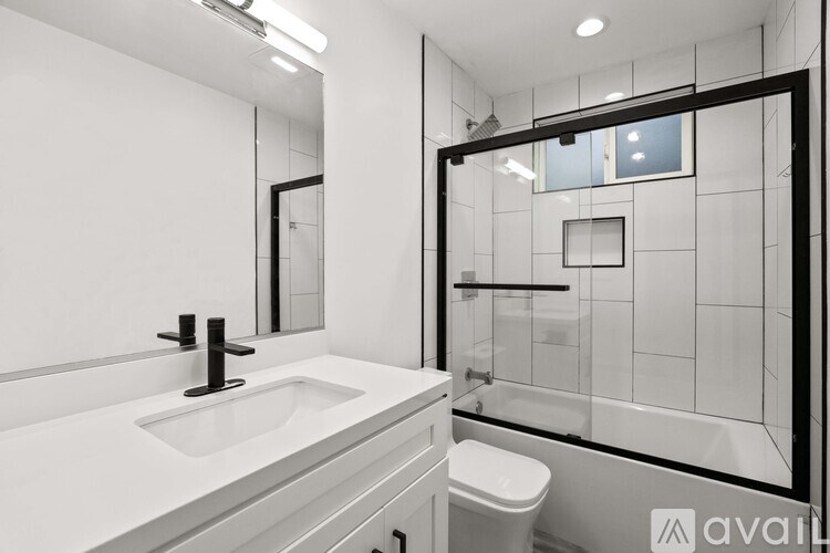 A bathroom with a white sink and toilet.