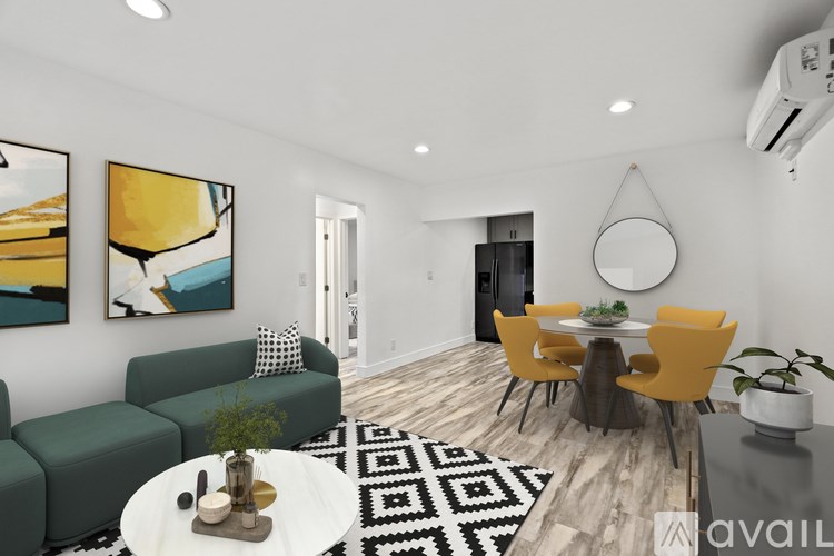 A modern living room with a green sofa, a coffee table, and a dining table with chairs.