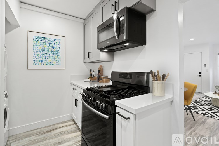 A modern kitchen with a black stove top oven and white cabinets.
