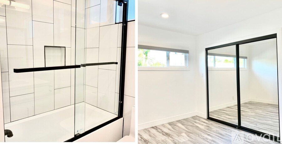 A modern bathroom with a glass shower enclosure and a wooden floor.