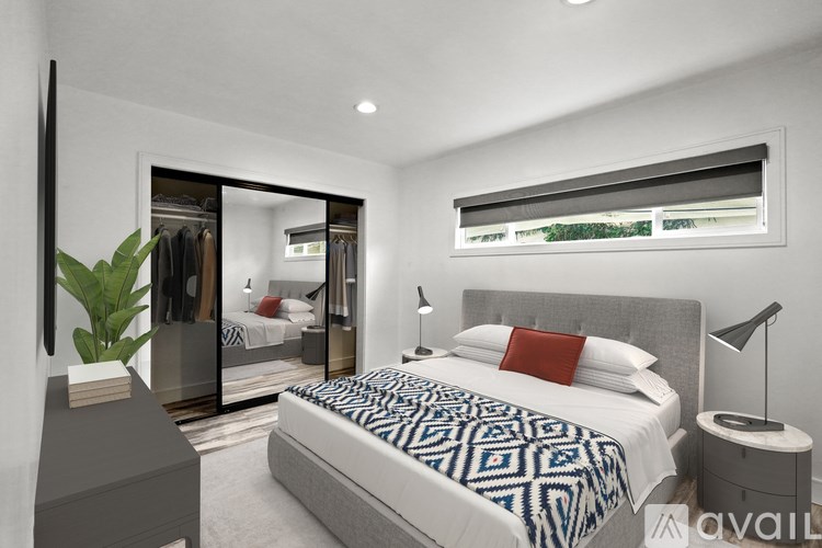 A bedroom with a large bed and a mirrored closet.