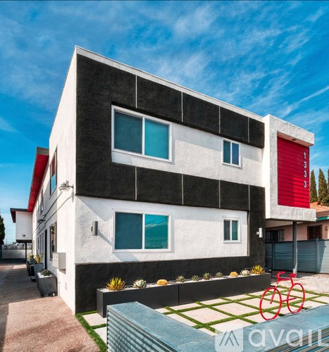 A modern house with a red bicycle in front.