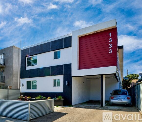 A modern two-story building with a red garage door numbered 1333.