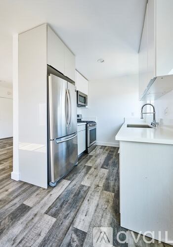 A kitchen with a white fridge and a white sink.