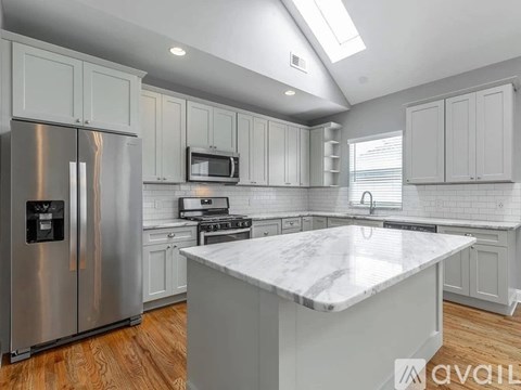 A kitchen with a marble countertop and stainless steel appliances.