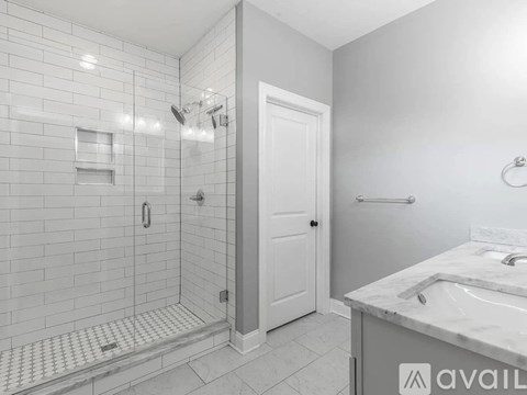 A bathroom with a marble countertop and a walk-in shower.