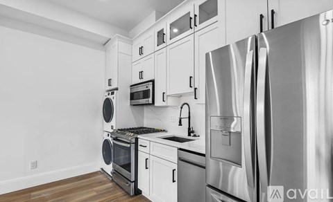 A modern kitchen with stainless steel appliances and white cabinetry.