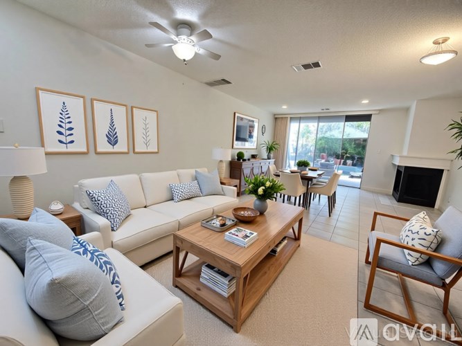 A living room with a white couch, a wooden coffee table, and a fireplace.