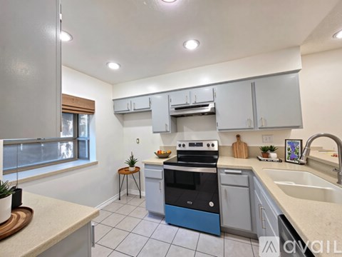 A kitchen with a blue oven and white cabinets.