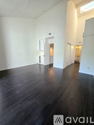 A room with wooden flooring and white walls.