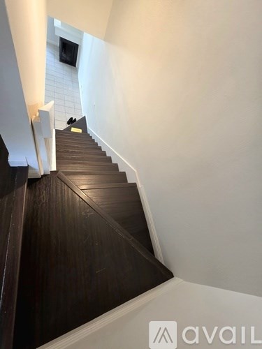 A staircase with wooden steps and white walls.