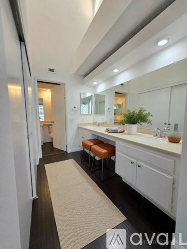 A bathroom with a white vanity and a mirror above it.