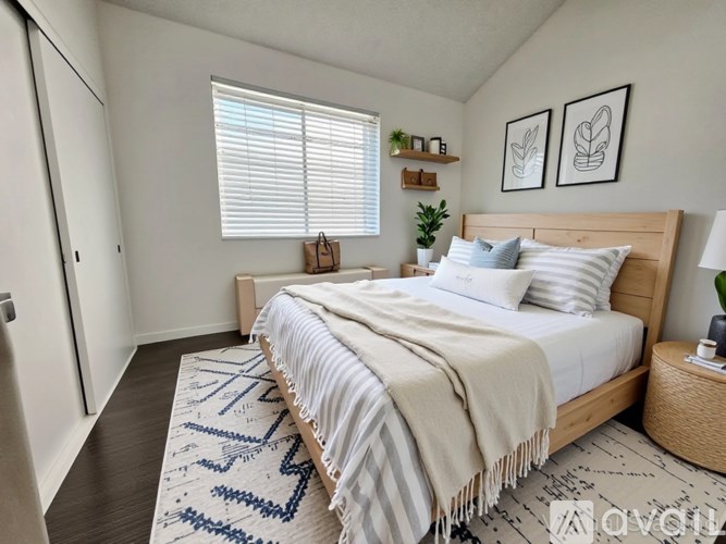 A bedroom with a bed, a rug, and two framed pictures on the wall.