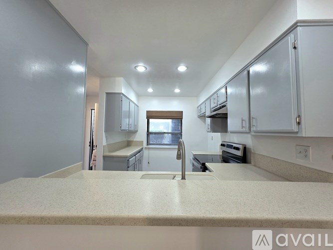 A kitchen with white cabinets and a countertop.