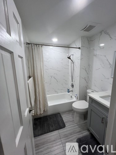 A bathroom with a marble wall and a white toilet.