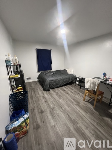 A bedroom with a bed, desk, and chair.