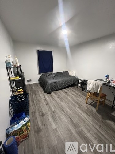 A bedroom with a bed, desk, and chair.