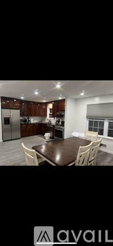 A modern kitchen with wooden cabinets and a dining table.