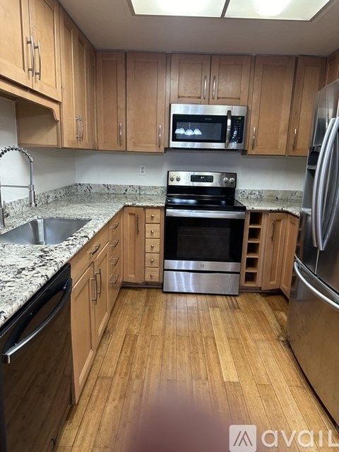 A kitchen with wooden cabinets and a black stove top oven.