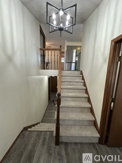 A staircase with a light on the ceiling and a door on the right.