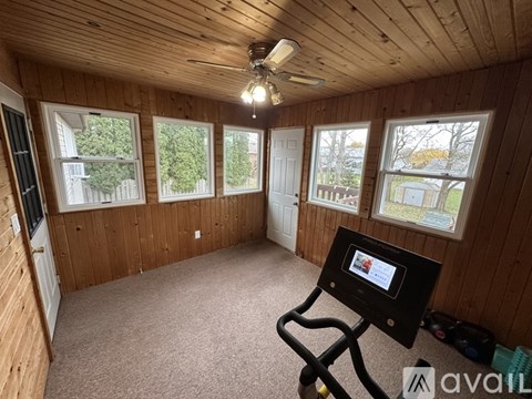 A room with wooden walls and a ceiling fan.