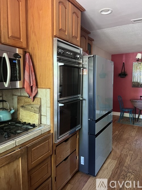 A kitchen with wooden cabinets and a black refrigerator.