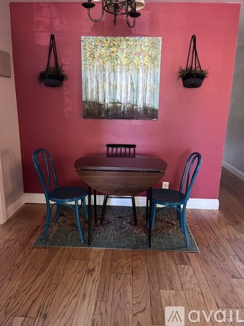 A dining room with a wooden table and chairs.