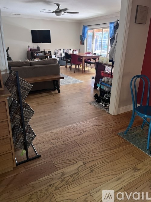 A living room with a couch, chairs, and a television.