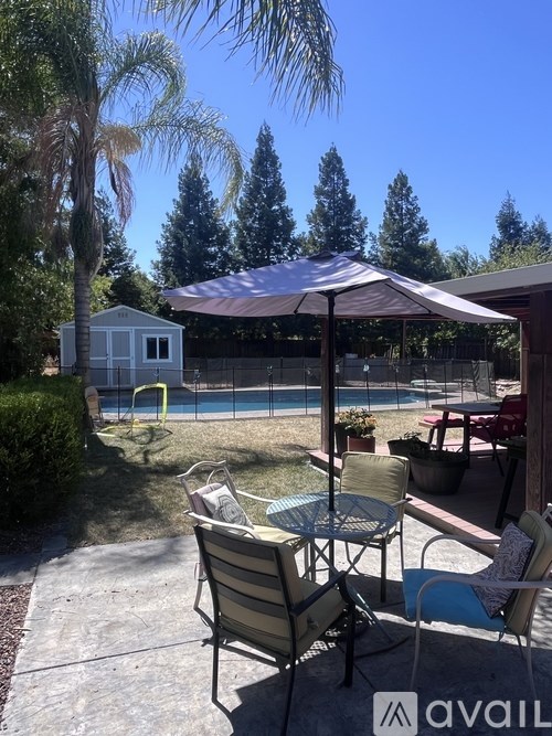 A patio with a table and chairs under a canopy.