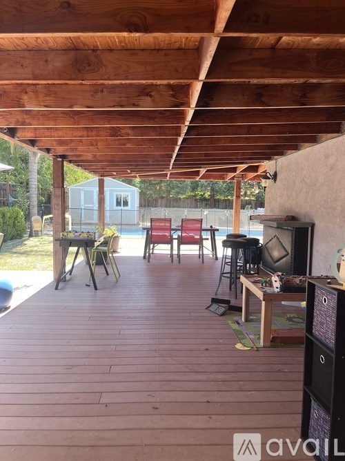 A wooden deck with a TV and chairs.