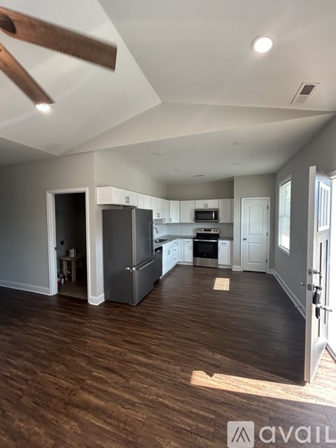 A kitchen with a refrigerator, oven, and microwave.