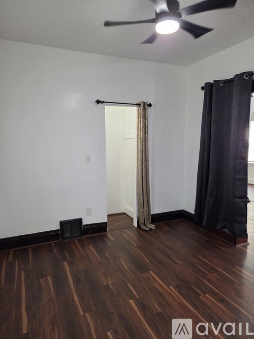 A room with a ceiling fan and a sliding door.