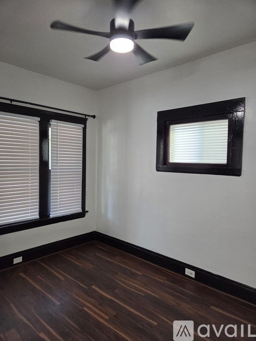 A room with a ceiling fan and a window with blinds.