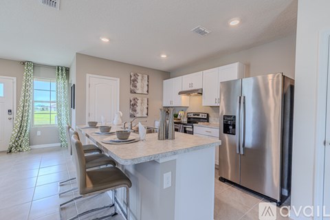 A kitchen with a table and chairs and a refrigerator.