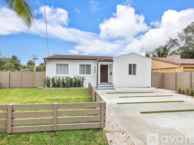 A white house with a wooden fence in front of it.