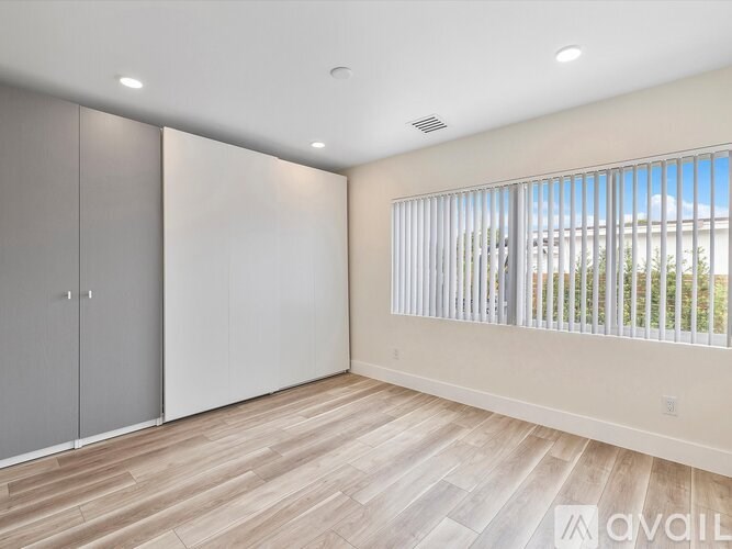 A room with a sliding door and a window with blinds.