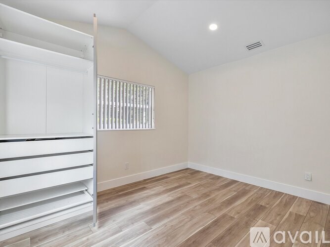 A room with a bunk bed and wooden flooring.