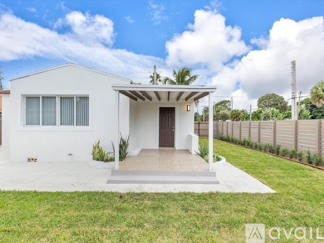 A white house with a brown door and a small porch.
