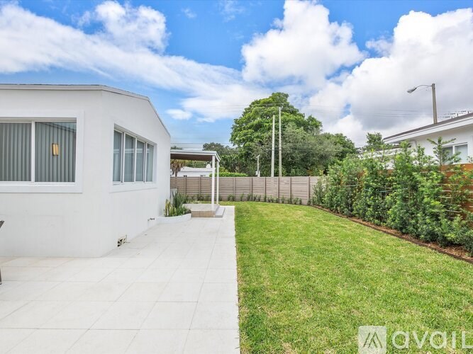 A white house with a white fence and a white walkway.