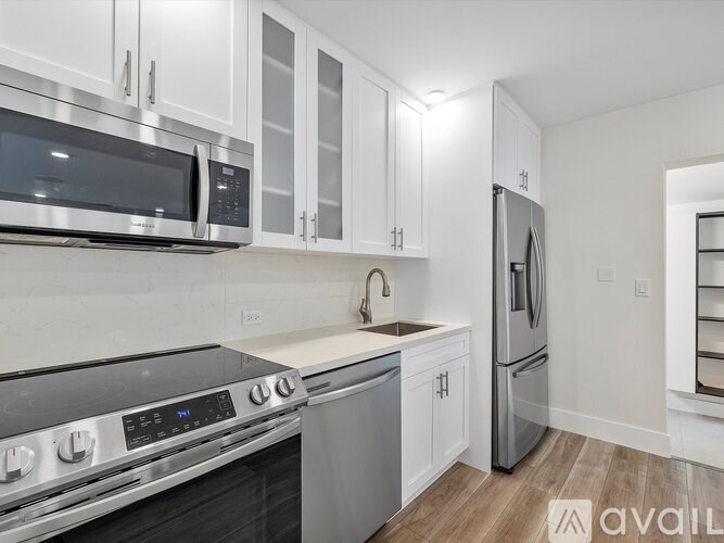 A kitchen with white cabinets and stainless steel appliances.