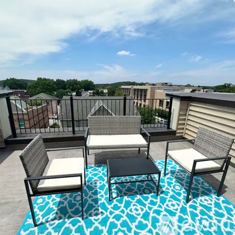 A patio with a table and chairs overlooking a residential area.