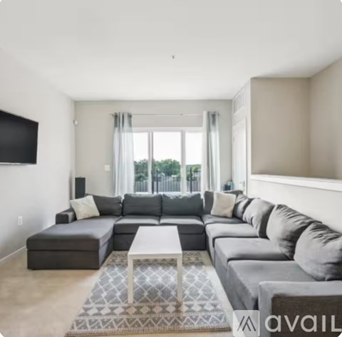 A modern living room with a grey sectional sofa and a white coffee table.