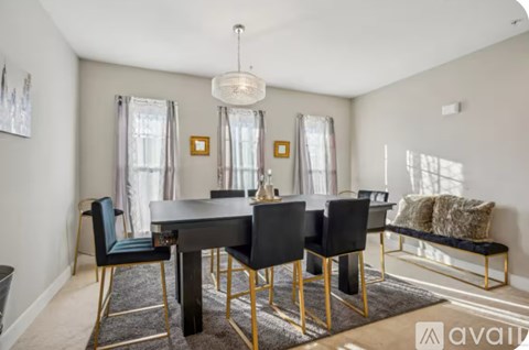 A dining room with a black table and chairs.