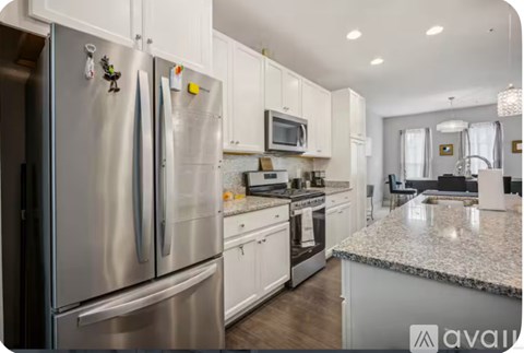 A kitchen with a refrigerator, microwave, and oven.