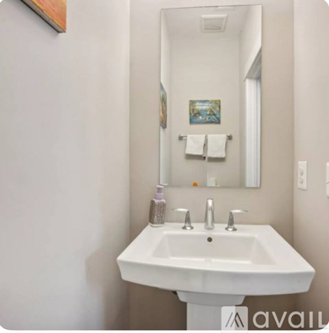 A white sink in a bathroom with a mirror above it.